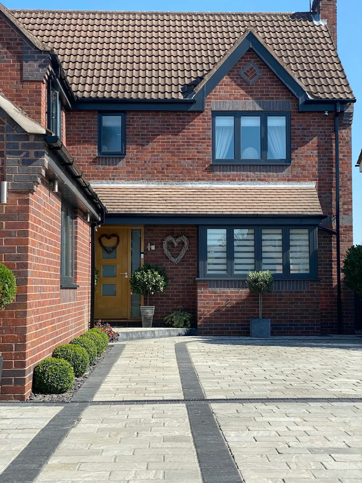 Paved driveway and entrance path beside a brick house