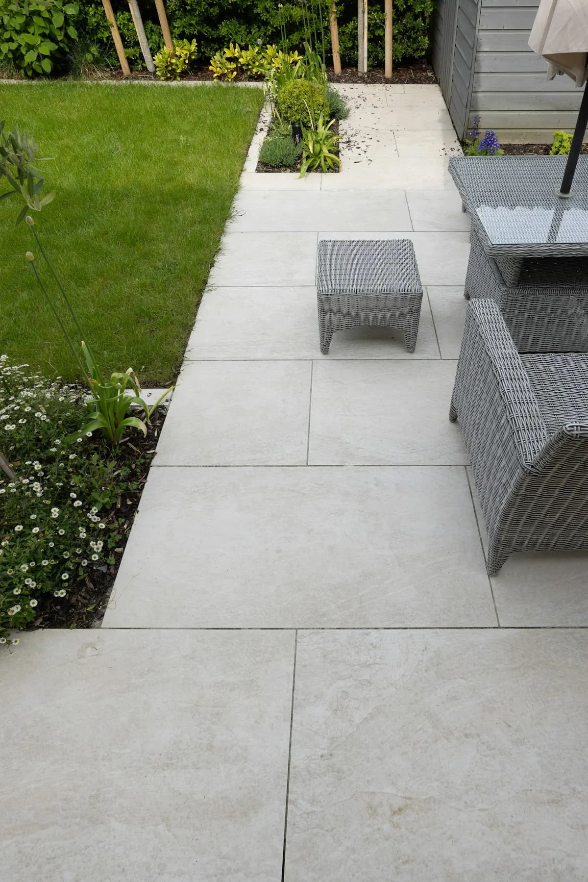 Large-format garden paving beside a planted border