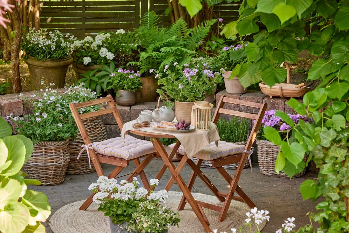 Small garden dining patio surrounded by plants