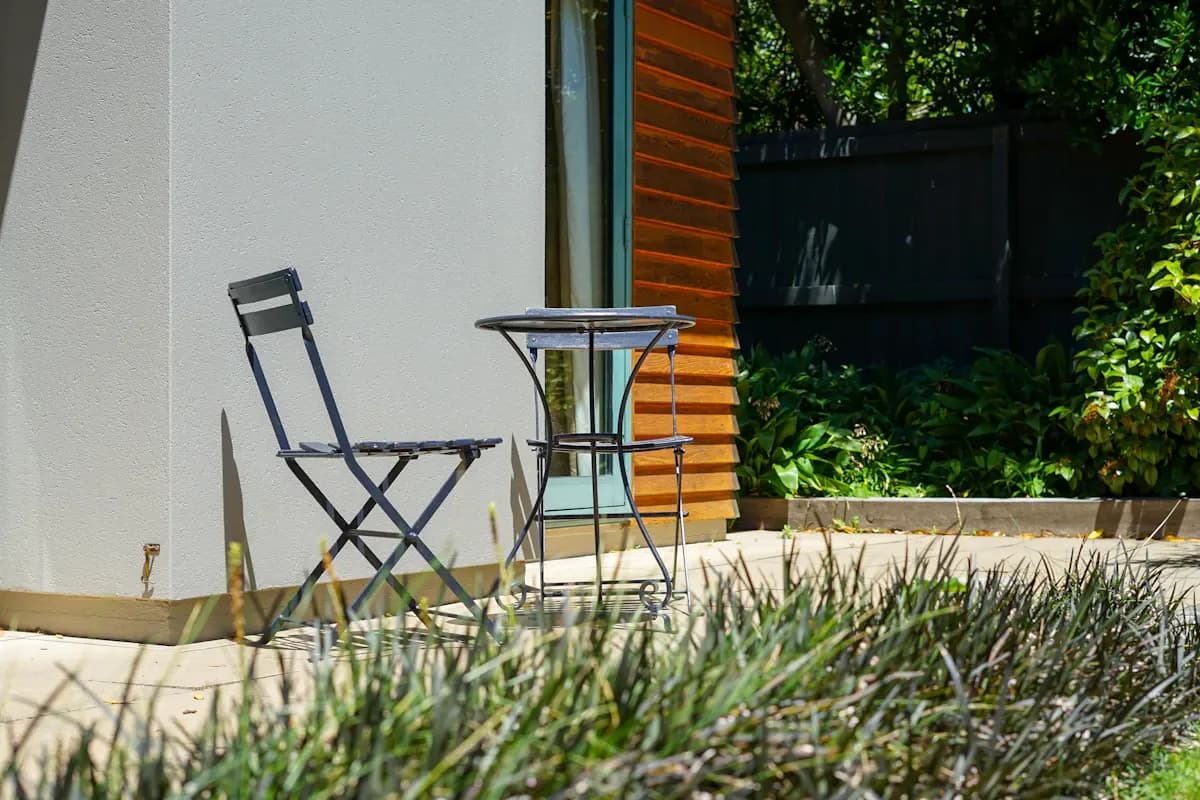 Small paved patio with a folding table and chairs