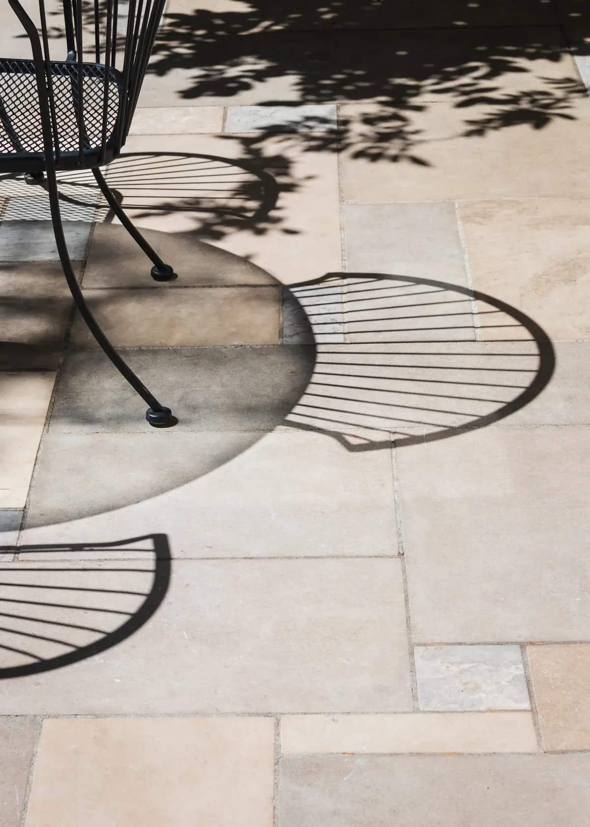 Close view of rectangular stone patio slabs beneath chairs